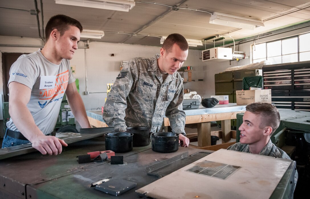 (From right) Senior Airman Noah Bergan, 934th Civil Engineering Squadron, shows his brothers, Staff Sgt. Nathanial Bergan, 934th Operation Support Squadron, and Trainee Andrew Bergan, 934th Development and Training Flight, some of the equipment around his workplace. All three brothers serve in the 934th Airlift Wing at the Minneapolis-St. Paul Air Reserve Station, Minn. (U.S. Air Force photo by Staff Sgt. Corban Lundborg/Released)