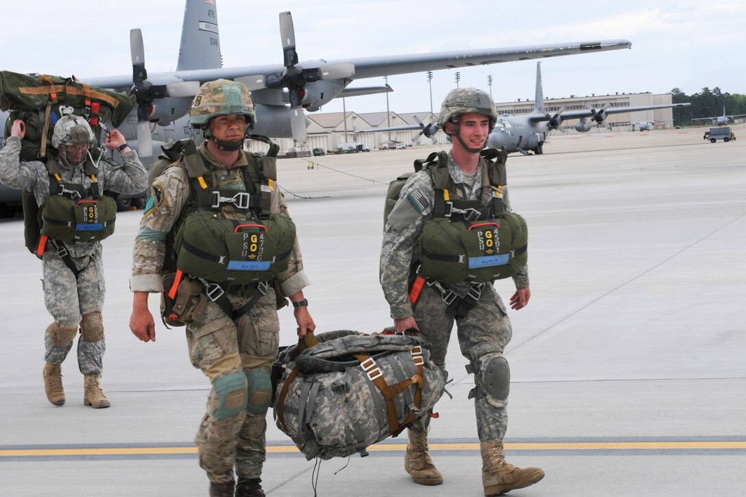 U.S. and British paratroopers carry gear to load onto a C-130 Hercules aircraft at Pope Army Airfield on Fort Bragg, N.C., April 13, 2015.