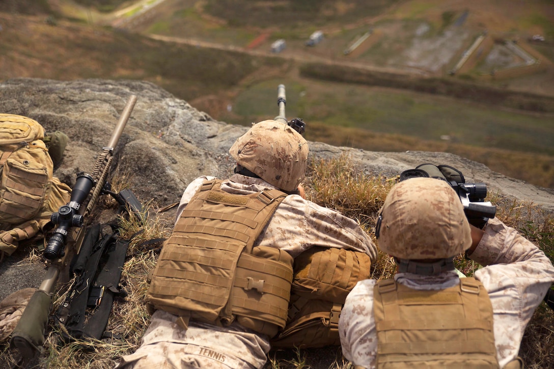 Marine Corps Cpls. Gabriel Tennis, left, and Curtis Cebula fire M40 and M110 sniper rifles at targets more than 800 meters (about 2,625 feet) downrange at Ulupau Crater on Marine Corps Base Hawaii, April 8, 2015. Tennis and Cebula are snipers assigned to Sniper Platoon, 2nd Battalion, 3rd Marine Regiment.