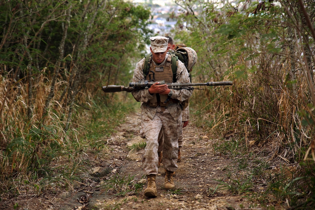 Marine Corps Lance Cpl. Ivan Trujillo, a scout, hikes up Ulupau Crater to Range 10 on Marine Corps Base Hawaii before conducting high-angle firing with his platoon, April 8, 2015. 