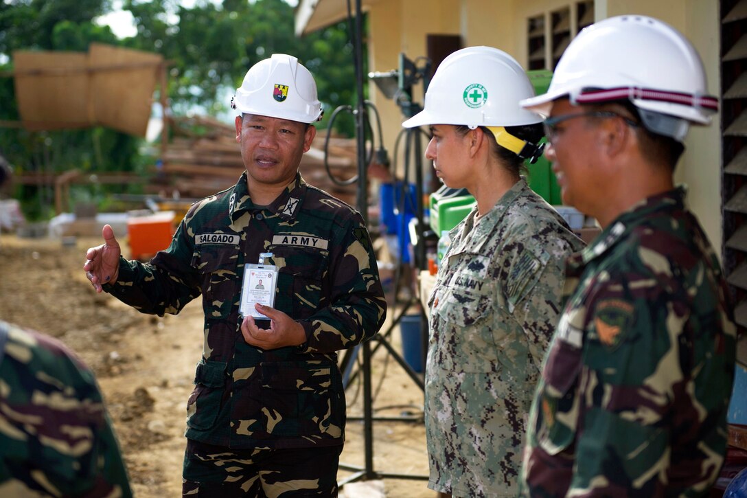 Philippine Army Lt. Col. Alexander Salgado, left, speaks with U.S. Navy Lt. Cmdr. Catherine Eyrich at Don Joaquin Artuz Memorial Elementary School during exercise Balikatan 2015 in Tapaz, Philippines, April 12, 2015. Eyrich is commander of the Combined-Joint Civil-Military Operations Task Force on Panay.