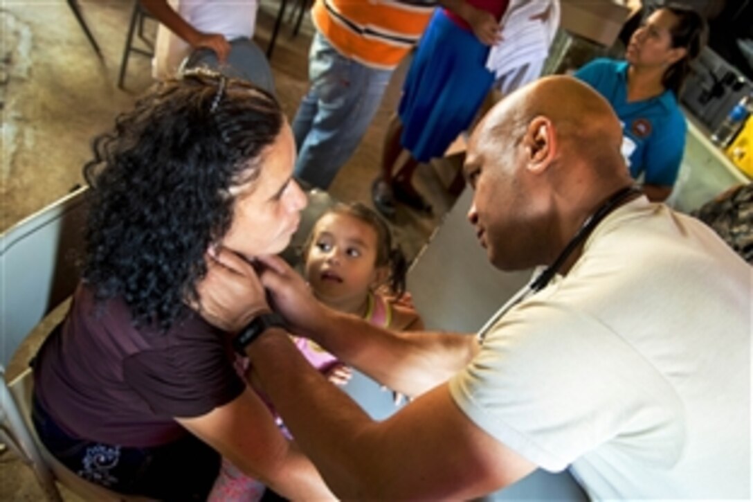 U.S. Army Maj. Angelo Carter checks a patient's lymph nodes during a medical readiness training exercise in support of the Beyond the Horizon 2015 mission in El Coco, El Salvador, April 13, 2015. Carter is a physician assistant assigned to the 349th Combat Support Hospital.