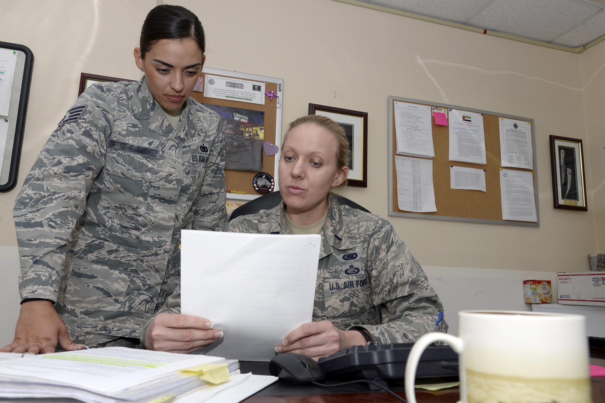 1st. Lt. Denise, right, installation deployment officer, and Staff Sgt. Elizabeth, logistics plans, review a document for an upcoming redeployment mission at an undisclosed location in Southwest Asia April 10, 2015. The focal point for all reception and redeployment operations is the Expeditionary Logistics Readiness Squadron Logistics Plans office. Denise is currently deployed from Grand Forks Air Force Base, N.D. and Elizabeth is currently deployed from Travis AFB, Calif. (U.S. Air Force photo/Tech. Sgt. Marie Brown/RELEASED)