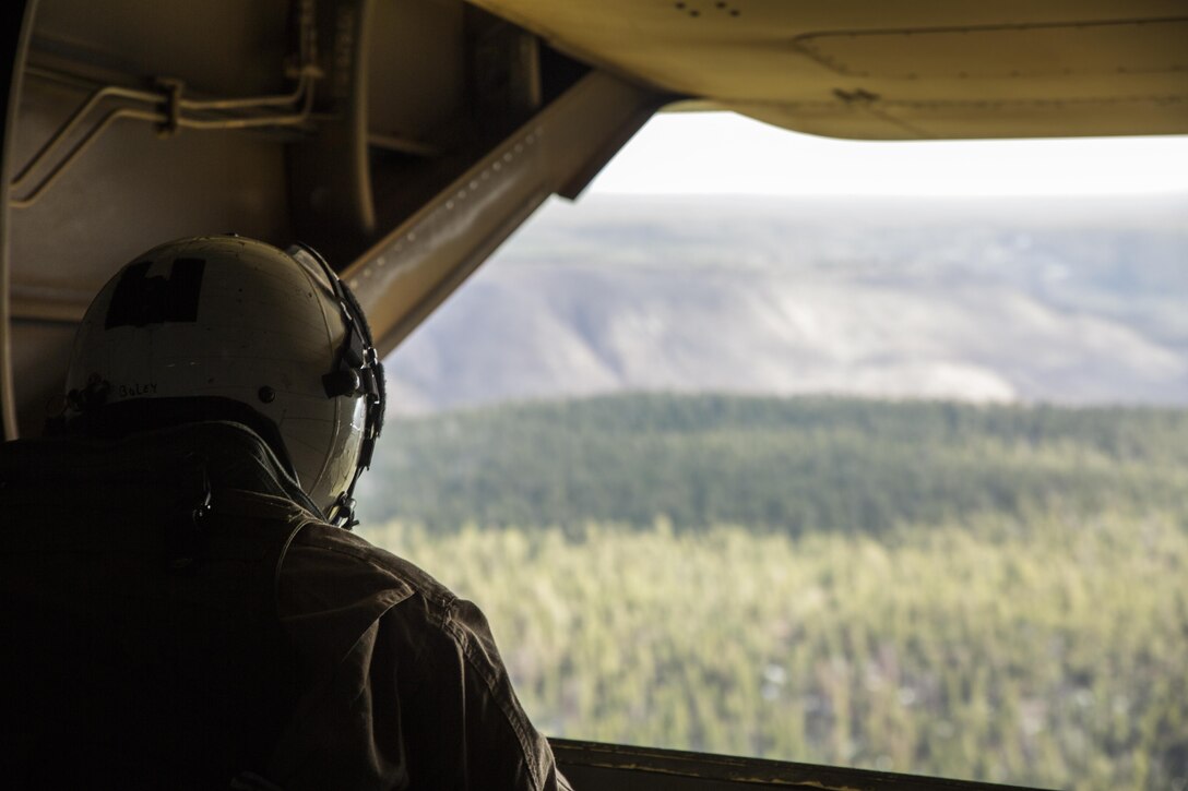 Lance Cpl. Paul Boley, a crew chief with Marine Operational Test and Evaluation Squadron 22, looks out the back of an MV-22B Osprey during a low altitude tactical flight aboard Kirtland Air Force Base, Albuquerque, New Mexico, April 2, 2015. During the flight, crew chiefs are the second pair of eyes for the pilot by helping them land and trouble-shoot potential problems. The crew chiefs are also responsible for maintaining and firing the aircraft’s weapons systems. (U.S. Marine Corps photo by Cpl. Andy J. Orozco/Released)