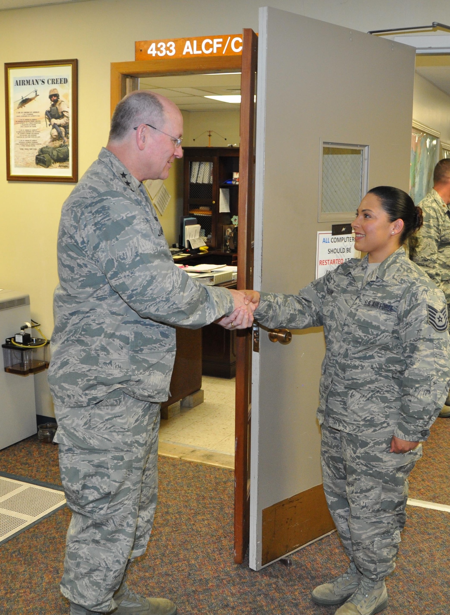 Lt. Gen. James Jackson, the Chief of Air Force Reserve and Commander of Air Force Reserve Command, recognizes Tech. Sgt. Crystal Olguin, a 433rd Airlift Control Flight Mobile C2 Operator, for her outstanding achievement during his visit April 11 to Joint Base San Antonio- Lackland, Texas. (U.S. Air Force photo by Capt. Cris Medina)