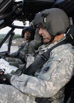 Chief Warrant 5 Gary Button, the Detachment 9-Operational Support Airlift commander reads the pre-flight check list as his son, Warrant Officer 1 Daniel Button, a pilot with Company A, 171st Aviation, checks the gauges of their UH-60 Black Hawk helicopter. Both are members of the Georgia National Guard. 