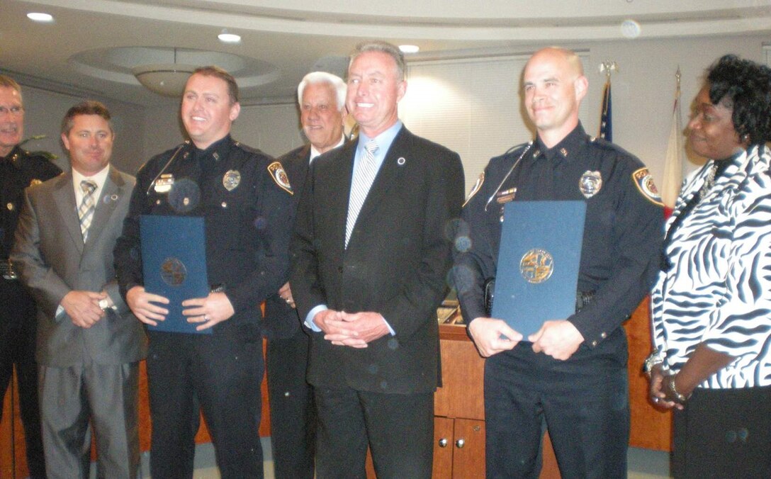Staff Sgt. Jeffrey Hilsman (officer on right) a communications technician with the 45th Aeromedical Evacuation Squadron, MacDill Air Force Base, Fla., recently received a proclamation from the Plant City, Fla., Mayor Rick Lott for his selfless acts of bravery. Hilsman a traditional reservist works fulltime as a Plant City police officer and while on duty, his actions resulted in three lives saved and the adversary eliminated. (Courtesy photo) 