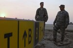 Lt. Col. David Burgess and Maj. Kipp Thompson, both members of the Maryland Air National Guard's 235th Civil Engineer Flight, inspect non-functional lighted signs and eroding soils adjacent to a taxiway at Basrah International Airport, Iraq during their recent deployment.