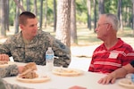 Officer Candidate Bennet Jones from Class 50, and former Army Capt. Jim McCarty from Class 1, discuss the challenges of the Louisiana National Guard's officer candidate school at a barbeque celebrating 50 years of excellence at Camp Beauregard in Pineville, La., Aug. 27, 2010.