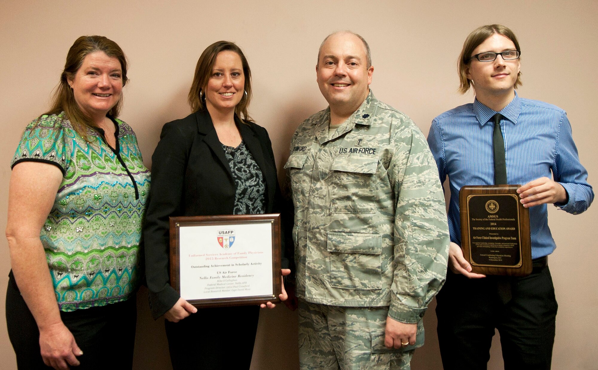Tracy Bogdanovich, the 99th Medical Operations Squadron clinical research coordinator; Jill Clark, the 99th MDOS clinical research manager; Lt. Col. Paul Crawford, the 99th MDOS Clinical Investigation Program and Family Medicine Residency program director; and Aaron Barnett, the 99th MDOS clinical research coordinator, pose for a photo at the Mike O’Callaghan Federal Medical Center on Nellis Air Force Base, Nev., April 6, 2015. The CIP was presented with the Association of Military Surgeons of the United States 2014 Training and Education Award and the FMR was presented with the 2015 Outstanding Achievement in Scholarly Activity Award by the Uniformed Services Academy of Family Physicians. (U.S. Air Force photo/Airman 1st Class Mikaley Towle)
