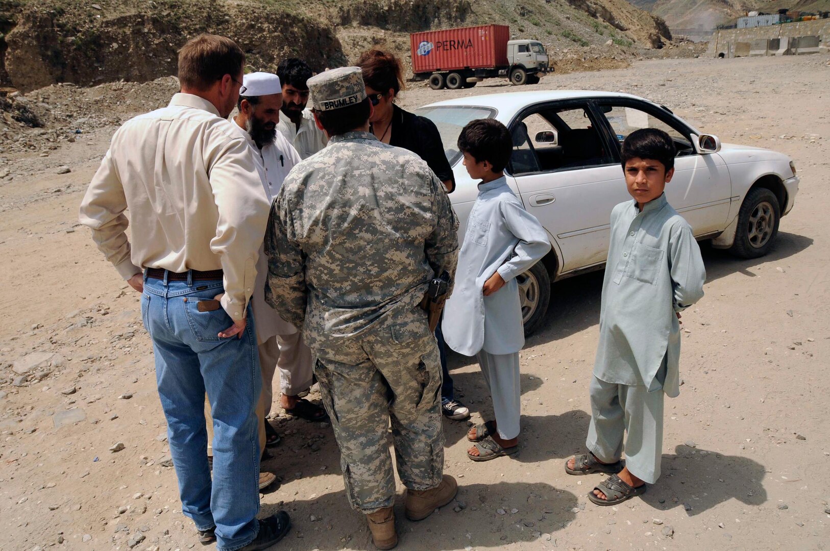 U.S. Army Sgt. 1st Class Melissa Brumley of the Iowa National Guard's 734th Agribusiness Development Team, speaks through an interpreter to staff members of the Kunar province director of Women's Affairs in eastern Afghanistan after loading their vehicle with supplies for local schoolgirls and clothes for the families of widows in the province Aug. 19, 2010.