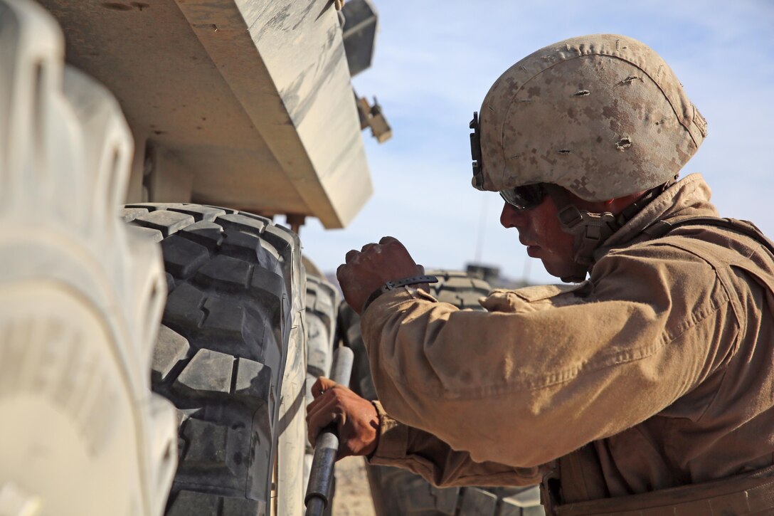 Cpl. Jeff A. Flores, Light Armored Vehicle crewman with LAV Platoon, Company B, Ground Combat Element Integrated Task Force, secures the lug nuts of an LAV wheel during the non-live fire portion of a Marine Corps Operational Test and Evaluation Activity assessment at Range 500, Marine Corps Air Ground Combat Center Twentynine Palms, California, March 29, 2015. From October 2014 to July 2015, the GCEITF will conduct individual and collective level skills training in designated ground combat arms occupational specialties in order to facilitate the standards-based assessment of the physical performance of Marines in a simulated operating environment performing specific ground combat arms tasks. (U.S. Marine Corps photo by Sgt. Alicia R. Leaders/Released)