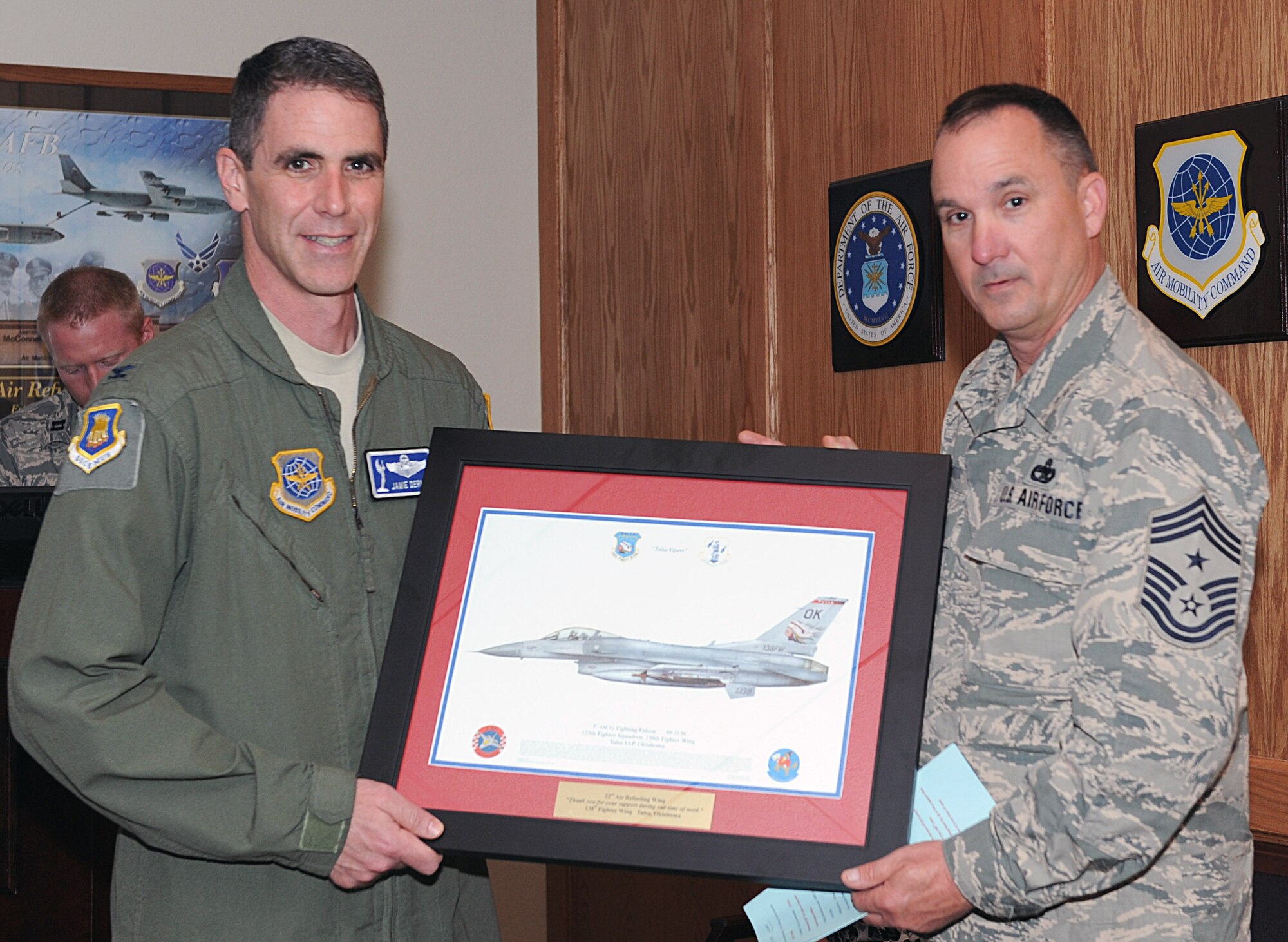 Col. James Dermer, left, 22nd Air Refueling Wing vice commander and Chief Master Sgt. Thomas Payne, Oklahoma Air National Guard 138th Fighter Wing command chief, pose for a photo April 15, 2015, at McConnell Air Force Base, Kan. Payne presented the 22nd ARW a plaque on behalf of the 138th FW, in appreciation of McConnell AFB’s assistance when they helped the 138th FW recover a downed F-16 Fighting Falcon when it crashed Oct. 20, 2014. McConnell Airmen provided support from the first response to the final aircraft recovery. (U.S. Air Force photo by Senior Airman David Bernal del Agua)   