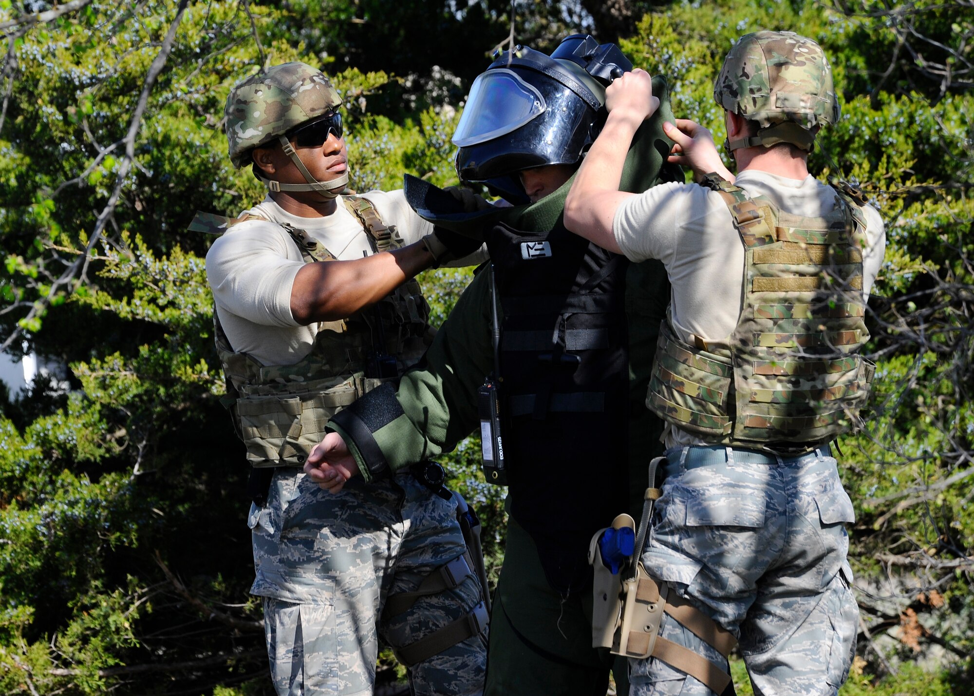 Airmen from the 22nd Civil Engineer Squadron Explosive Ordnance Disposal team help a wingman don protective equipment, April 7, 2015, at McConnell Air Force Base, Kan. The 22nd CES EOD team responds to an average of 12 off-base calls a year, helping cover three quarters of Kansas and one quarter of Oklahoma. (U.S. Air Force photo by Senior Airman Victor J. Caputo)