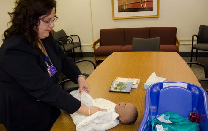 Sandra Walker-Halliman, 628th Medical Group Family Advocacy Nurse, demonstrates how to properly swaddle a baby for the New Parent Support program April 14, 2015 at Joint Base Charleston – Air Base, S.C. This program provides education for expecting or new parents with children up to 3-years old. (U.S. Air Force photo/Staff Sgt. AJ Hyatt)