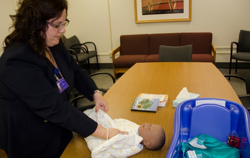Sandra Walker-Halliman, 628th Medical Group Family Advocacy Nurse, demonstrates how to properly swaddle a baby for the New Parent Support program April 14, 2015 at Joint Base Charleston – Air Base, S.C. This program provides education for expecting or new parents with children up to 3-years old. (U.S. Air Force photo/Staff Sgt. AJ Hyatt)