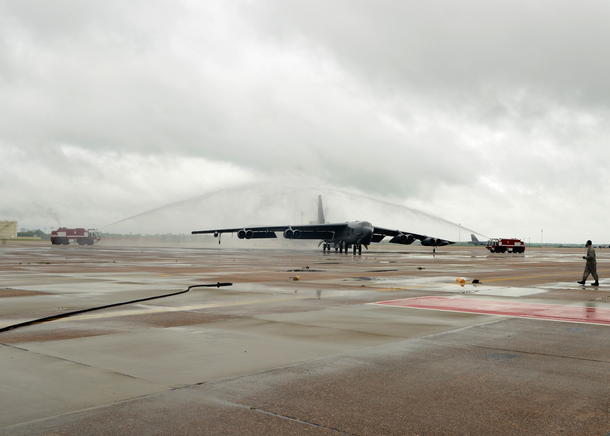 A B-52H Stratofortress piloted by Maj. Gen. Scott Vander Hamm, 8th Air Force commander, and aircrew members taxi under streams of water on Barksdale Air Force Base, La., April 13, 2015. Firefighters shot water over the aircraft as part of the celebration for Vander Hamm's final flight on Barksdale. (U.S. Air Force photo/Senior Airman Joseph A. Pagan Jr.)