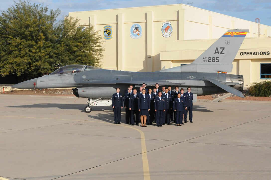 Personnel from the 162nd Wing Host Aviation Resource Management office pose for a group photo in front of one of the wing's F-16 Falcon's. The wing HARM office won the Sergeant Dee Campbell Outstanding Aviation Resource Management Large Unit of the Year award for 2014, and were presented with the award April 11 during the wing's annual awards ceremony.
