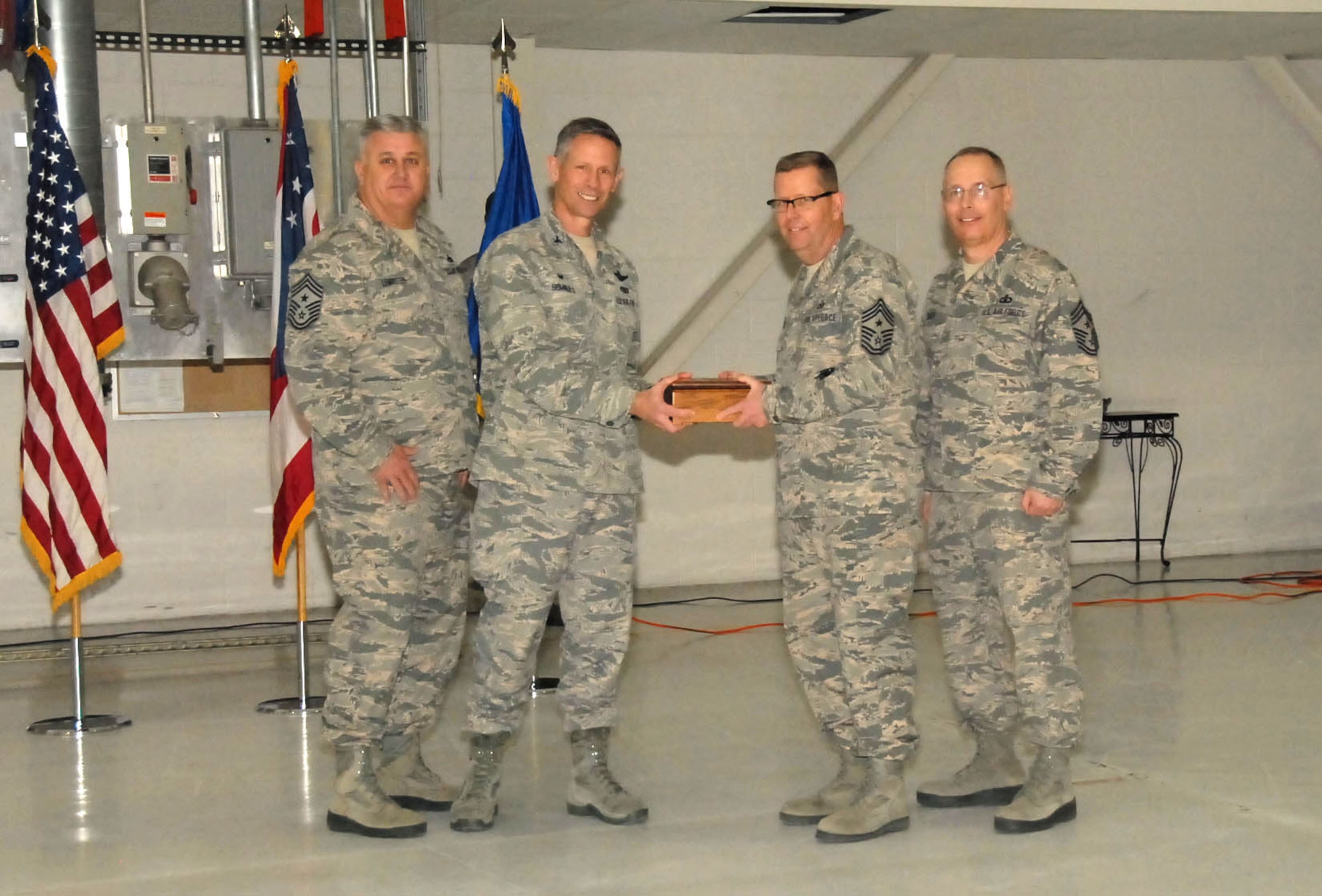 178th Wing Commander Col. Gregory Schnulo passes an engraved Command Chiefs Box to incoming 178th Command Chief Scott McKenzie at Springfield Air National Guard Base, April 11. The change of responsibility  is passed from outgoing 178th Command Chief Ottis LeMaster (left) to McKenzie. (Ohio Air National Guard photo by Airman Rachel Simones/Released)