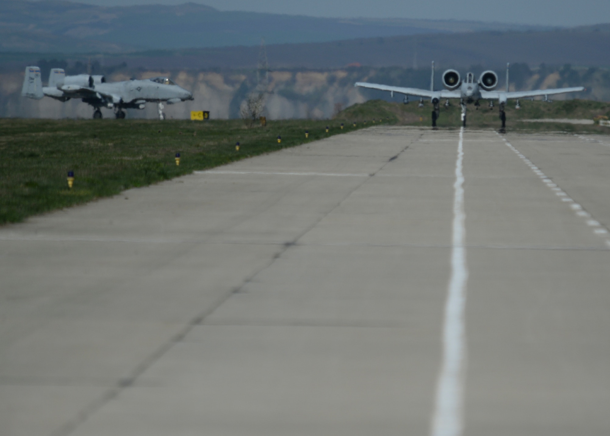 Two U.S. Air Force A-10 Thunderbolt II aircraft assigned to the 354th Expeditionary Fighter Squadron taxi on the runway during a theater security package deployment at Campia Turzii, Romania, April 14, 2015. U.S. Airmen will conduct training alongside NATO allies to strengthen interoperability and demonstrate U.S. commitment to the security and stability of Europe. (U.S. Air Force photo by Staff Sgt. Joe W. McFadden/Released)