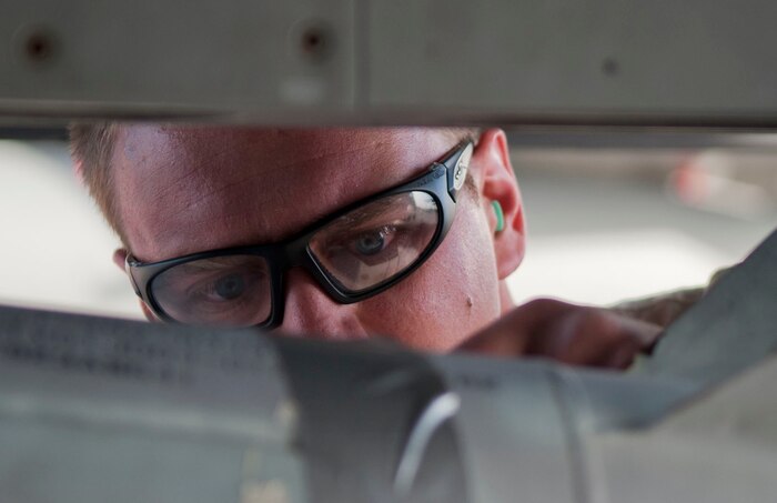 Senior Airman Bradley Meyer, Viper Aircraft Maintenance Unit weapons load crew member, ensures that a munition is properly secured during a quarterly weapons load crew competition at Nellis Air Force Base, Nev., April 10, 2015. The competitions give weapons loaders throughout the 57th Maintenance Group the opportunity to display their war-fighting skills to their peers and superiors. (U.S. Air Force photo by Airman 1st Class Mikaley Towle)