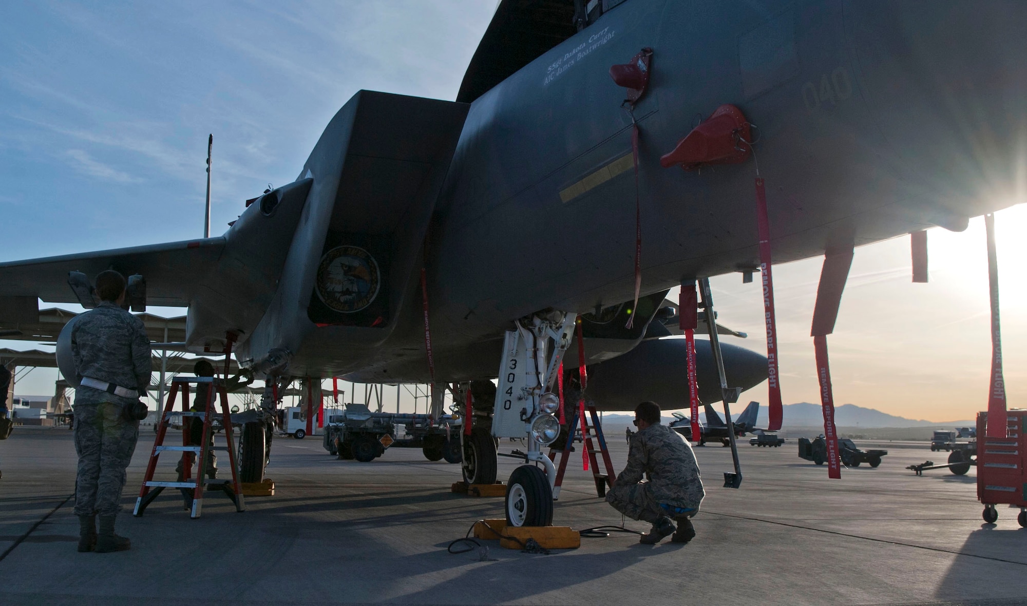 Quarterly weapons load crew competition  watch as Eagle Aircraft Maintenance Unit weapons load crew members perform during a quarterly weapons load crew competition at Nellis Air Force Base, Nev., April 10, 2015. 57th Maintenance Group load crews were competing to see which crew could correctly load weapons on to their respective aircraft the quickest. (U.S. Air Force photo by Airman 1st Class Mikaley Towle)