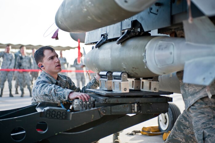 Staff Sgt. Travis Brown, Strike Aircraft Maintenance Unit weapons load crew member, loads a munition onto an F-15 Eagle during a quarterly weapons load crew competition at Nellis Air Force Base, Nev., April 10, 2015. Weapons load crews compete in the quarterly competition for a chance to determine the best crew at Nellis AFB. (U.S. Air Force photo by Airman 1st Class Jake Carter)
