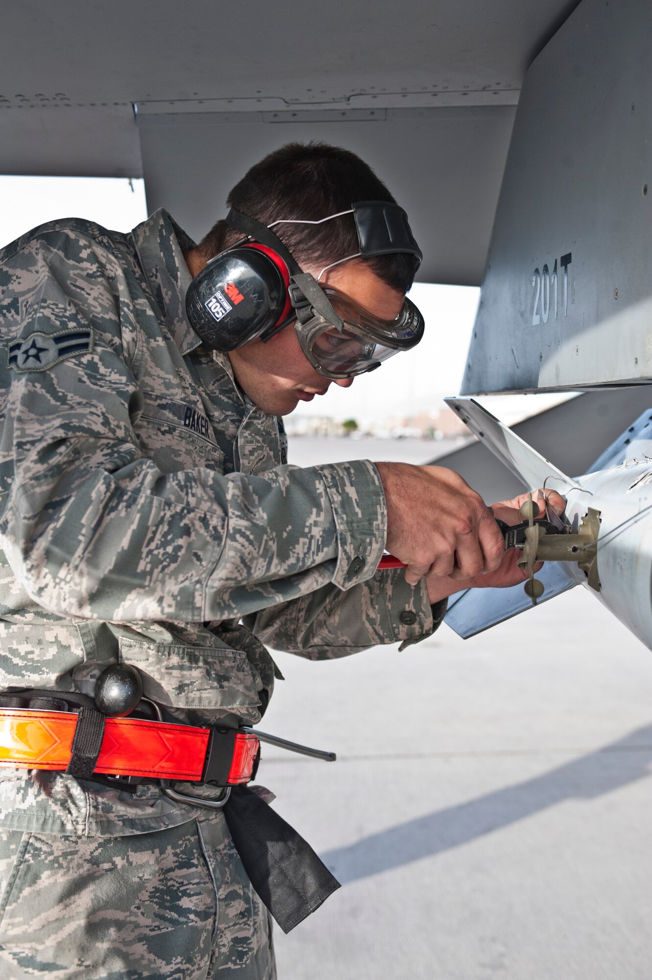 Airman 1st Class Cory Baker, Tomahawk Aircraft Maintenance Unit weapons load crew member, prepares a munition during a quarterly weapons load crew competition at Nellis Air Force Base, Nev., April 10, 2015. Weapons load crew competitions test each participant’s ability to load ordnance onto their assigned aircraft in a safe, efficient and correct manner. (U.S. Air Force photo by Airman 1st Class Jake Carter)