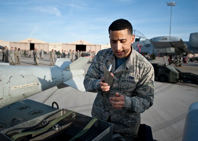 Airman 1st Class Christopher Alvarez, Lightning Aircraft Maintenance Unit weapons load crew member, inspects a component of a munition during a quarterly weapons load crew competition at Nellis Air Force Base, Nev., April 10, 2015. During a competition, each weapons load crew member has a set of tasks to carry out and work in teams of three to properly load weapons on an aircraft. (U.S. Air Force photo by Staff Sgt. Siuta B. Ika)