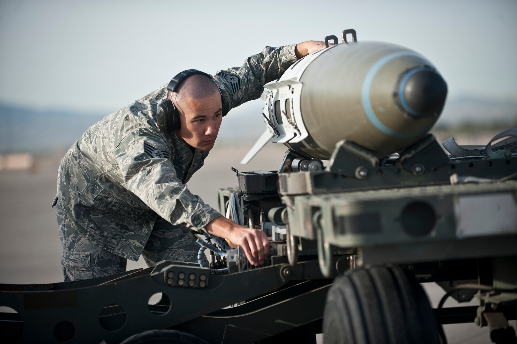 Staff Sgt. Frank Tauanuu, Raptor Aircraft Maintenance Unit weapons load crew member, helps guide a munition onto a jammer during a quarterly weapons load crew competition at Nellis Air Force Base, Nev., April 10, 2015. In addition to recognizing superior performers, load crew competitions also help keep weapons loaders’ skills sharp and ready for real-world situations. (U.S. Air Force photo by Staff Sgt. Siuta B. Ika)