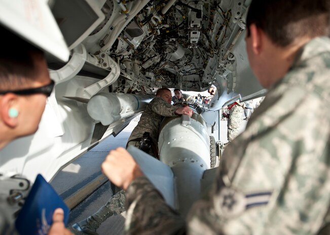 A weapons load crew from Lightning Aircraft Maintenance Unit prepares to load a munition on an F-35A Lightning II during a quarterly weapons load crew competition at Nellis Air Force Base, Nev., April 10, 2015. In order for load crews to earn their place in the competition, they must prove themselves during monthly proficiency loads, quarterly evaluations and every-day mission. (U.S. Air Force photo by Staff Sgt. Siuta B. Ika)