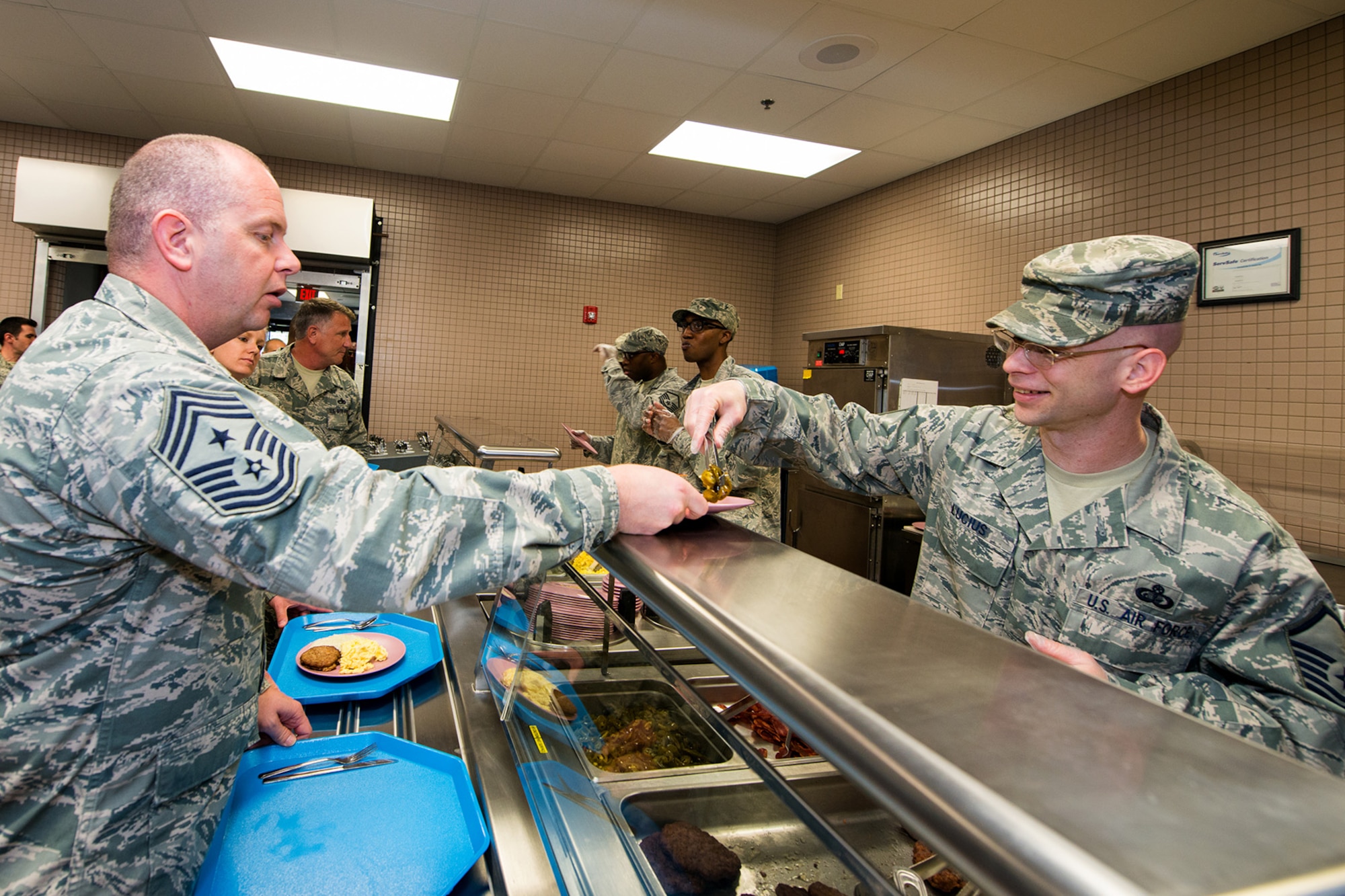 U.S. Air Force Master Sgt. Nicholas Lucius, from the 169th Force Support Squadron's Services Flight, proudly serves lunch to Chief Master Sgt. James W. Hotaling, Command Chief Master Sgt. for the Air National Guard, during the chief's visit to the South Carolina Air National Guard's 169th Fighter Wing at McEntire Joint National Guard Base, S.C., April 11, 2015. Hotaling hosted town hall meetings to engage Swamp Fox Airmen in the discussion of three key points; the profession of arms, the health of the force and recognizing and renewing commitments to Airmen. (U.S. Air National Guard photo by Tech. Sgt. Jorge Intriago/RELEASED)