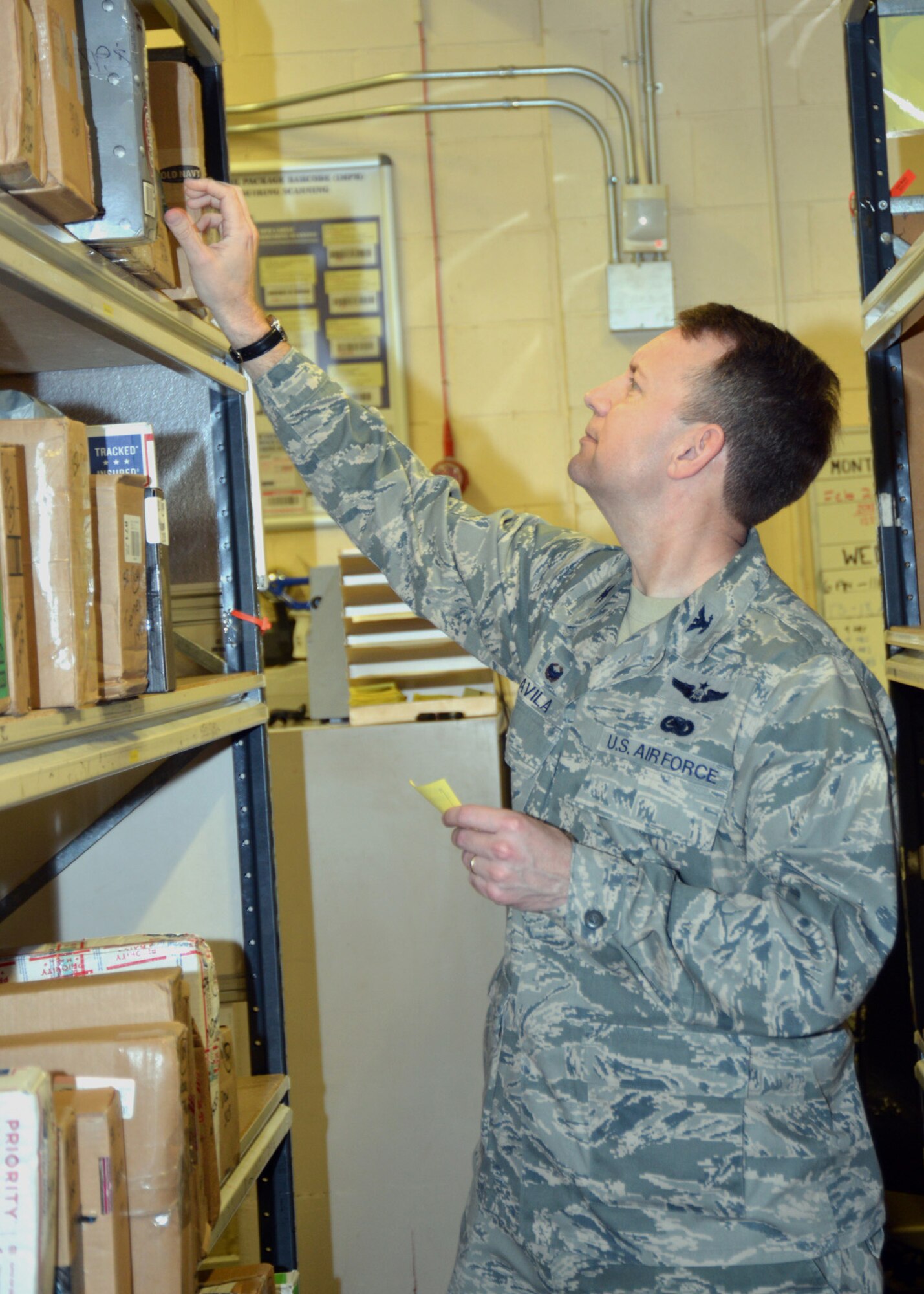 U.S. Air Force Col. David Avila, 100th Mission Support Group commander, searches for a package for a customer during a job shadow event April 14, 2015, at the post office on RAF Mildenhall, England. The 100th MSG job shadow program is scheduled to be held monthly and allows an Airman from a squadron within the 100th MSG to spend a day with the commander. It provides an opportunity for Airmen to gain a greater perspective of the 100th MSG mission and show them how their role ties in with the mission of the group, the 100th Air Refueling Wing and U.S. Air Forces in Europe. (U.S. Air Force photo by Karen Abeyasekere/Released)