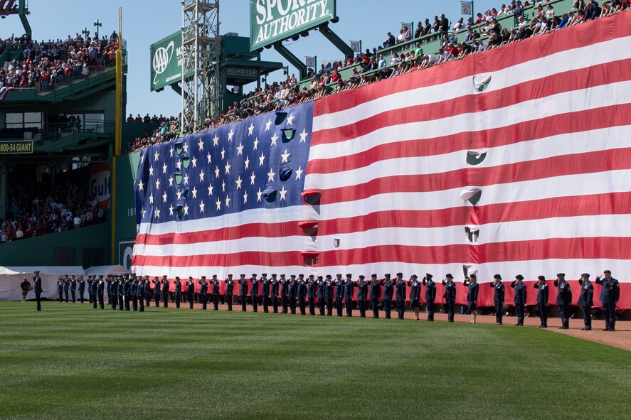Airmen from Hanscom Air Force Base salute during the playing of the national anthem at Fenway Park for Boston Red Sox opening day festivities April 13. After the first pitch, the Airmen gathered the American flag from the Green Monster and carried it off the field. (U.S. Air Force photo by Mark Herlihy)
