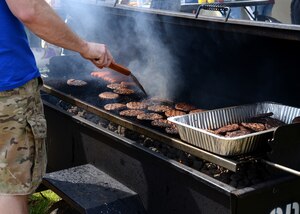 A Langley Top 3 member barbeques burgers and hot dogs for junior-enlisted Airmen at Langley Air Force Base, Va., April 11, 2015. The cookout included music, food, drinks and an opportunity to connect and socialize. (U.S. Air Force photo by Airman 1st Class Devin S. Michaels/Released)