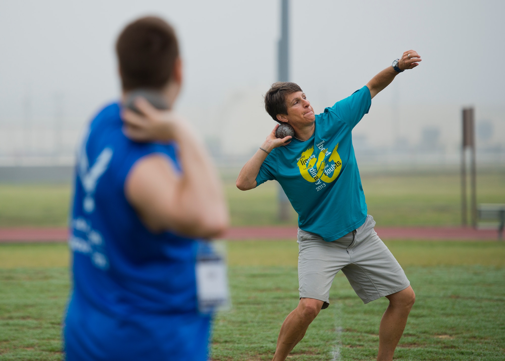 An Air Force Wounded Warrior athlete watches as Coach Erica Wheeler demonstrates shot put technique during the second day of an introductory adaptive sports and rehabilitation camp at Eglin Air Force Base, Fla., April 14. The DOD’s military adaptive sports program enhances warrior recovery by engaging wounded, ill and injured service members in ongoing, daily adaptive activities, based on their interest and ability. (U.S. Air Force photo/Samuel King Jr.)