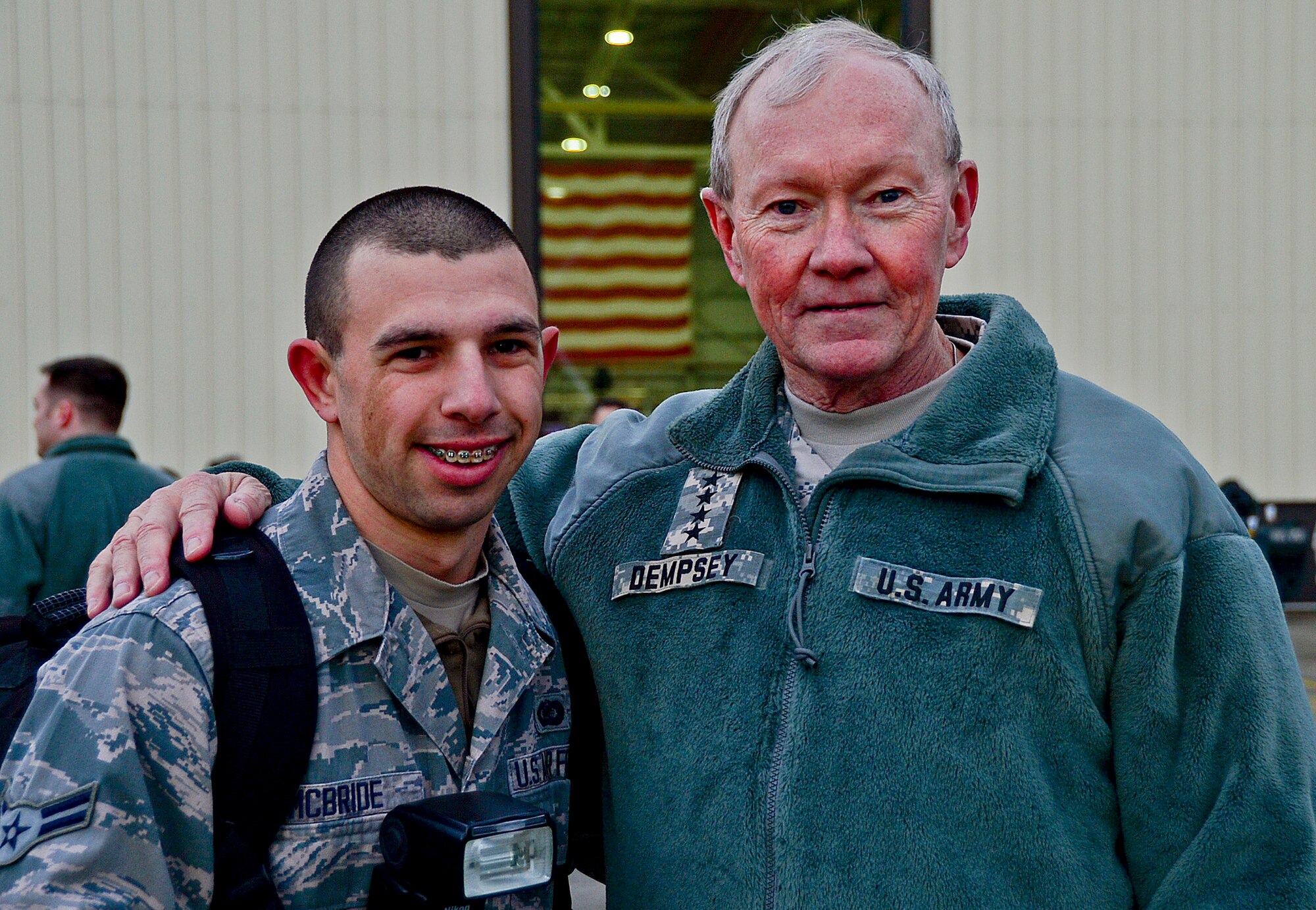 Senior Airman Trevor McBride, 48th Fighter Wing Public Affairs photojournalist, meets Army Gen. Martin E. Dempsey, 18th Chairman of the Joint Chiefs of Staff, at a USO holiday troop visit at Royal Air Force Mildenhall, England, Dec. 10, 2014. The visit is a tradition in which the USO partners with senior leaders and celebrity entertainers to see troops serving abroad during the holidays. (U.S. Air Force photo by Senior Airman Erin O’Shea/Released) 
