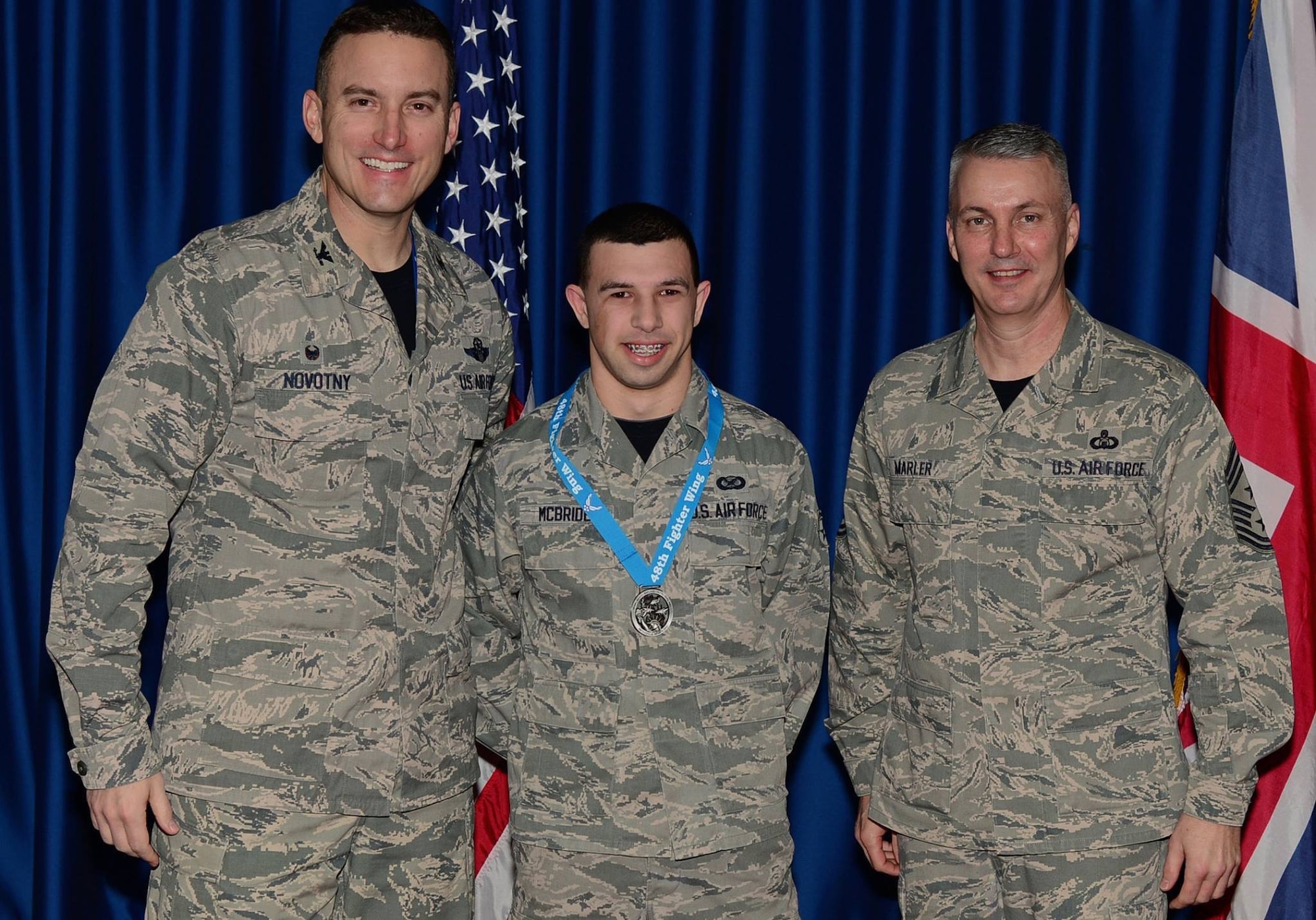Senior Airman Trevor McBride, 48th Fighter Wing Public Affairs photojournalist, center, stands with Col. Robert Novotny, 48th FW commander, and Chief Master Sgt. Vincent Marler, 48th FW command chief, during the 2014 Annual Awards banquet at Royal Air Force Lakenheath, England, Feb. 13, 2015. McBride was recognized as Airman of the Year for the 48th FW Wing Staff Agencies. (U.S. Air Force photo by Airman 1st Class Erin R. Babis/Released)
