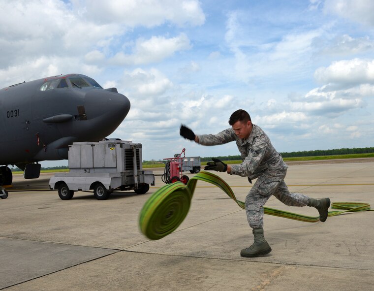 Senior Airman Cameron Kizzia, 307th Civil Engineer Squadron firefighter, unrolls a fire hose on the flightline of Barksdale Air Force Base, La., April 8, 2015. Barksdale firefighters’ first priority is the aircraft and flightline where they train in order to hone their skills and optimize response times and procedures. (U.S. Air Force photo/Airman 1st Class Curt Beach)
