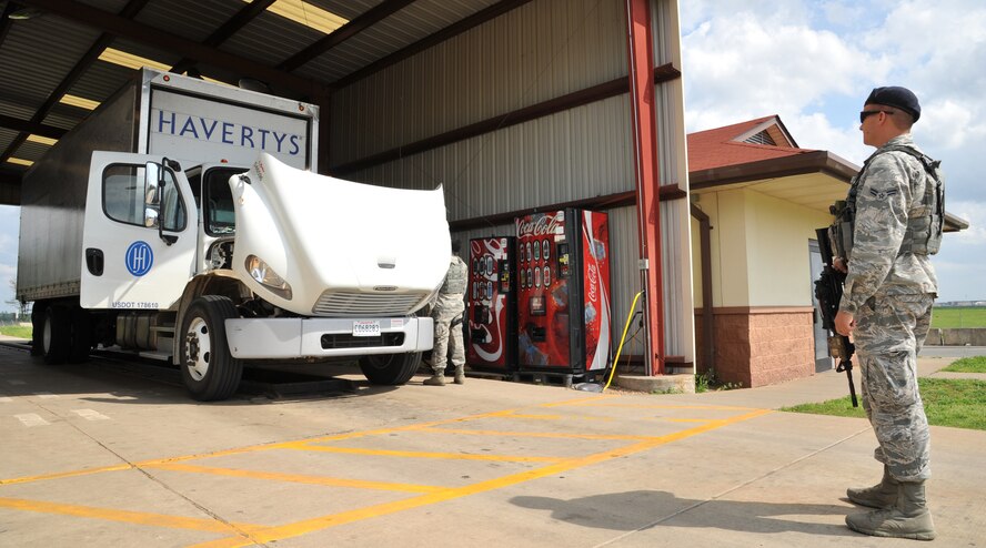 Airman 1st Class Rhett Meyers, 2nd Security Force Squadron vehicle search overwatch, stands guard as a driver opens all compartments of his vehicle for inspection on Barksdale Air Force Base, La., April 8, 2015. Each vehicle is searched carefully before being allowed access to the base. (U.S. Air Force photo/Senior Airman Joseph Raatz)