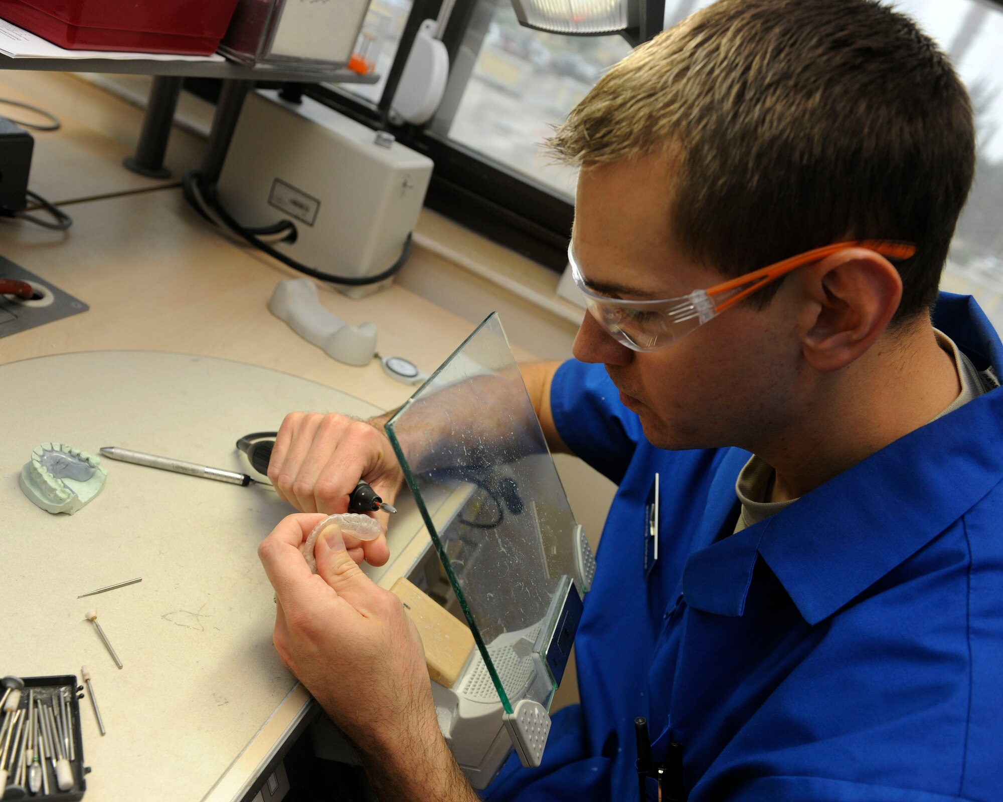 Tech. Sgt. Doug Ickes, 39th Medical Operations Squadron NCO in-charge of dental lab, polishes a hard night guard April 9, 2015, at Incirlik Air Base, Turkey. The dental lab creates all dental appliances such as night guards, retainers and crowns for service members and their families in Turkey. (U.S. Air Force photo by Senior Airman Krystal Ardrey/Released)