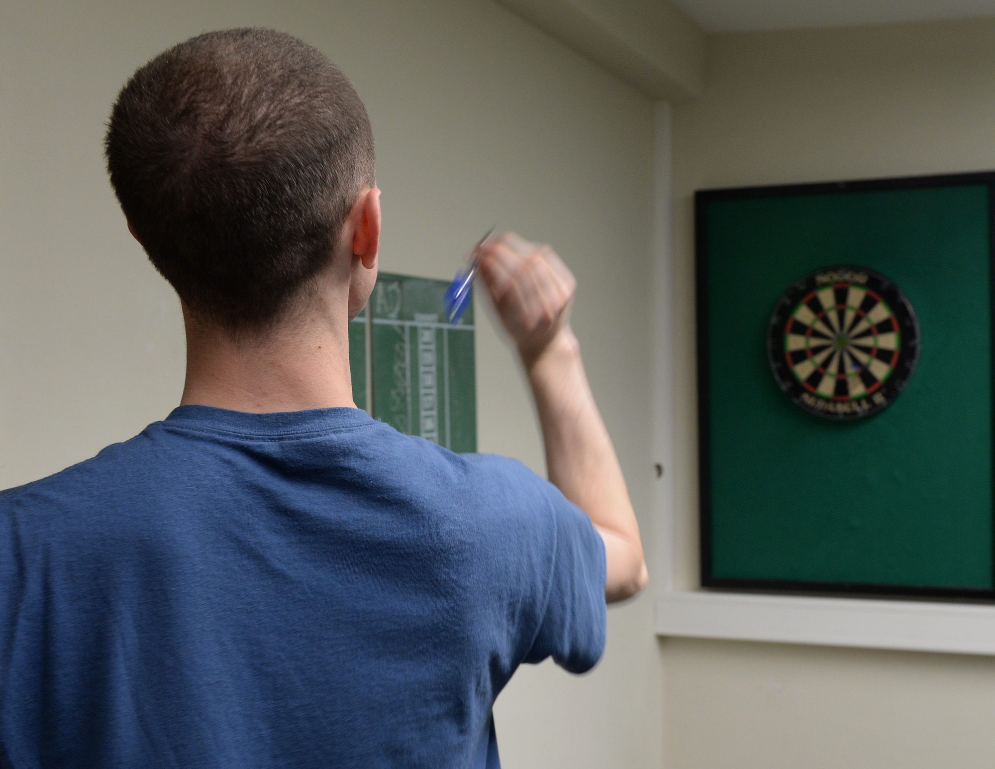 A U.S. Air Force Airman competes in a game of darts, at the Coffee Mill on Spangdahlem Air Base, Germany, April 10, 2015. The chapel recently purchased a new pingpong table and air hockey table. It also has a pool table, darts, flat screen TV's, board and video games. (U.S. Air Force photo by Senior Airman Dylan Nuckolls/Released)