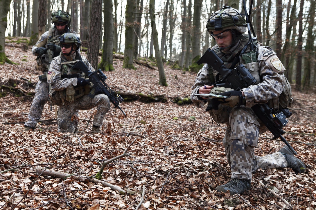 A Latvian soldier, right, looks at his map while conducting zone reconnaissance during exercise Saber Junction 15 on Germany's Grafenwoehr Training Area, April 12, 2015. The Latvian soldiers are assigned to 2nd Company, 1st Battalion, Latvian Land Forces.