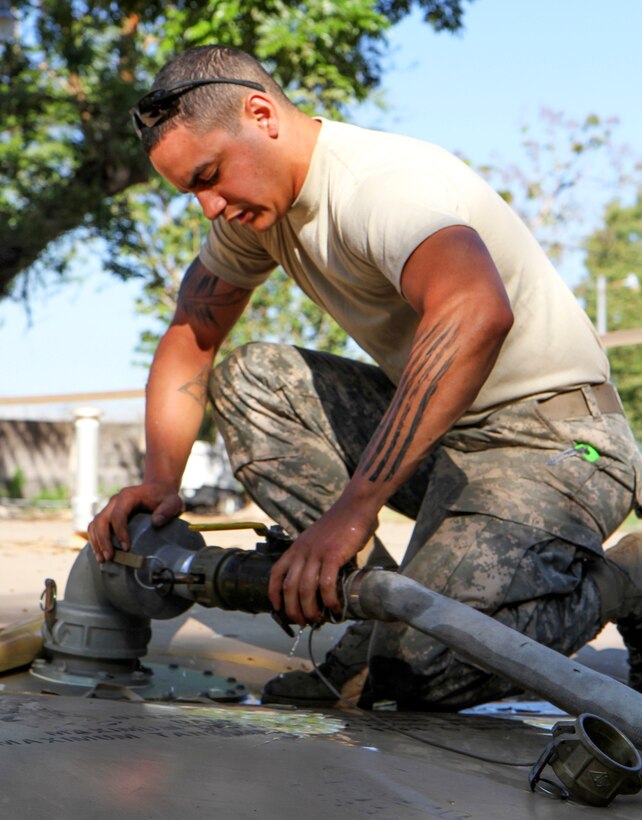 U.S. Army Spc. Eric N. Bryant connects a water purification unit hose to a water storage unit during Beyond the Horizon 2015 in El Salvador, April 4, 2015. Bryant is a water treatment specialist assigned to the 14th Quartermaster Company.