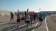 Servicemembers carry crosses during a Good Friday “Cross” fit event, April 3, 2015, at Al Udeid Air Base, Qatar. During the event, several chaplains and chaplain assistants, from the Air Force, Army and Navy shared readings and prayers based on the last seven statements of Christ on the cross. After each devotion, members of the community took turns carrying three crosses for a lap around the track. (Courtesy photo)
