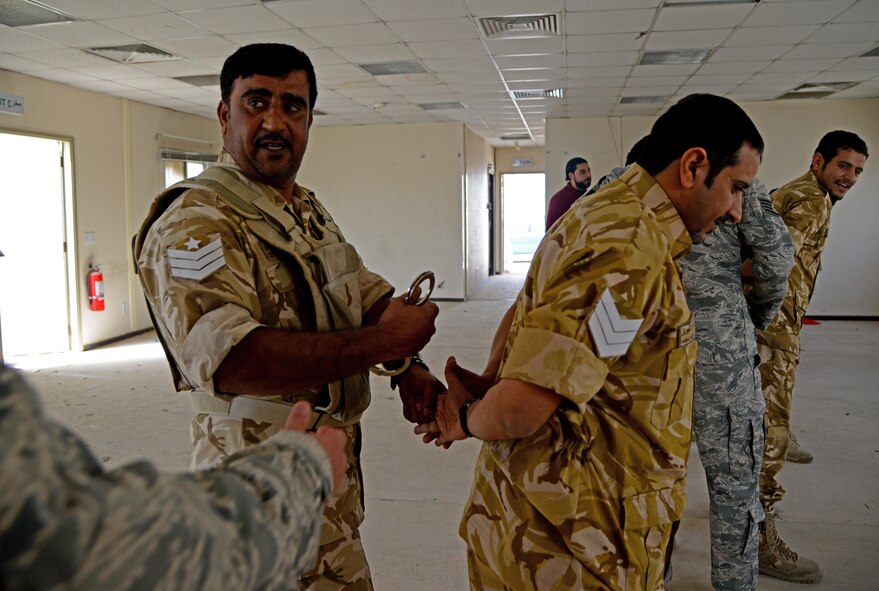 Members of the Qatar Emiri Air Force practice handcuffing techniques during joint interoperability training April 14, 2015, at Al Udeid Air Base, Qatar. Airmen from the 379th Expeditionary Security Forces Squadron shared techniques and procedures with members of the QEAF during the joint training. Training enhances the interoperability of both the U.S. and its host nation partners and helps improve bilateral relations by sharing techniques on how each country operates. (U.S. Air Force photo/Senior Airman Kia Atkins)