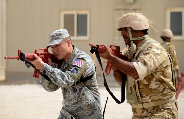 U.S. Air Force Staff Sgt. Jason Ventura, 379th Expeditionary Security Forces Squadron Check Six facilitator, demonstrates proper weapon holding procedures during joint interoperability training April 14, 2015, at Al Udeid Air Base, Qatar. Airmen from the 379th ESFS shared techniques and procedures with members of the Qatar Emiri Air Force during this joint training. Training like this enhances the interoperability of both the U.S. and its host nation partners and helps improve bilateral relations by sharing techniques on how each country operates. (U.S. Air Force photo by Senior Airman Kia Atkins)