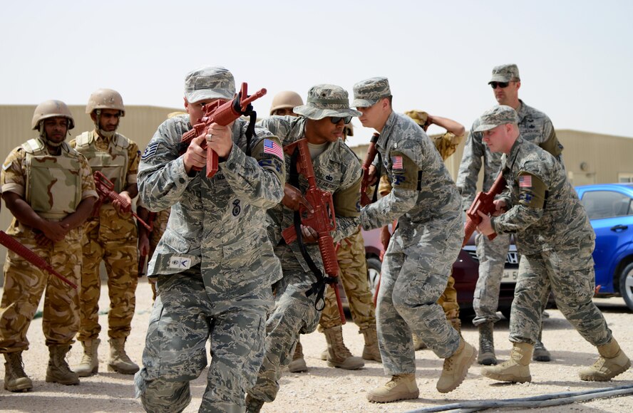 Airmen from the 379th Expeditionary Security Forces Squadron demonstrate building clearing procedures to members of the Qatar Emiri Air Force during joint interoperability training April 14, 2015, at Al Udeid Air Base, Qatar. Airmen from the 379th ESFS shared techniques and procedures with members of the QEAF during the joint training. Training enhances the interoperability of both the U.S. and its host nation partners and helps improve bilateral relations by sharing techniques on how each country operates. (U.S. Air Force photo/Senior Airman Kia Atkins)