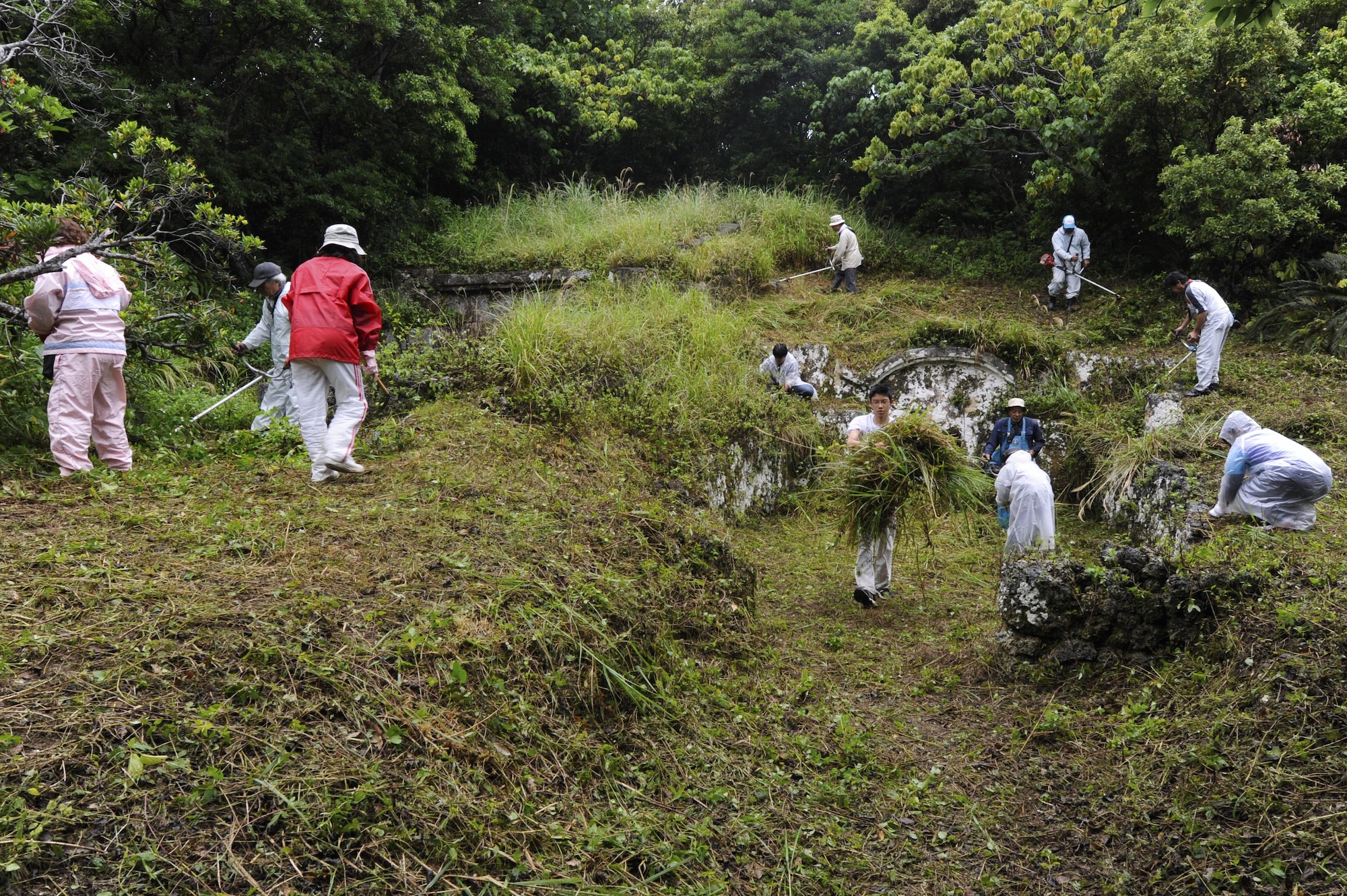 Okinawans clear overgrown plants from the area surrounding their family tomb in preparation for Shimi at Kadena Air Base, Japan, April 12, 2015. Shimi is an annual celebration on Okinawa, during which family tombs and the surrounding areas are cleaned before extended family members gather to pray and offer food to their ancestors. More than 400 locals visited the base this year to pray, eat and enjoy each other’s company. (U.S. Air Force photo/Staff Sgt. Marcus Morris)