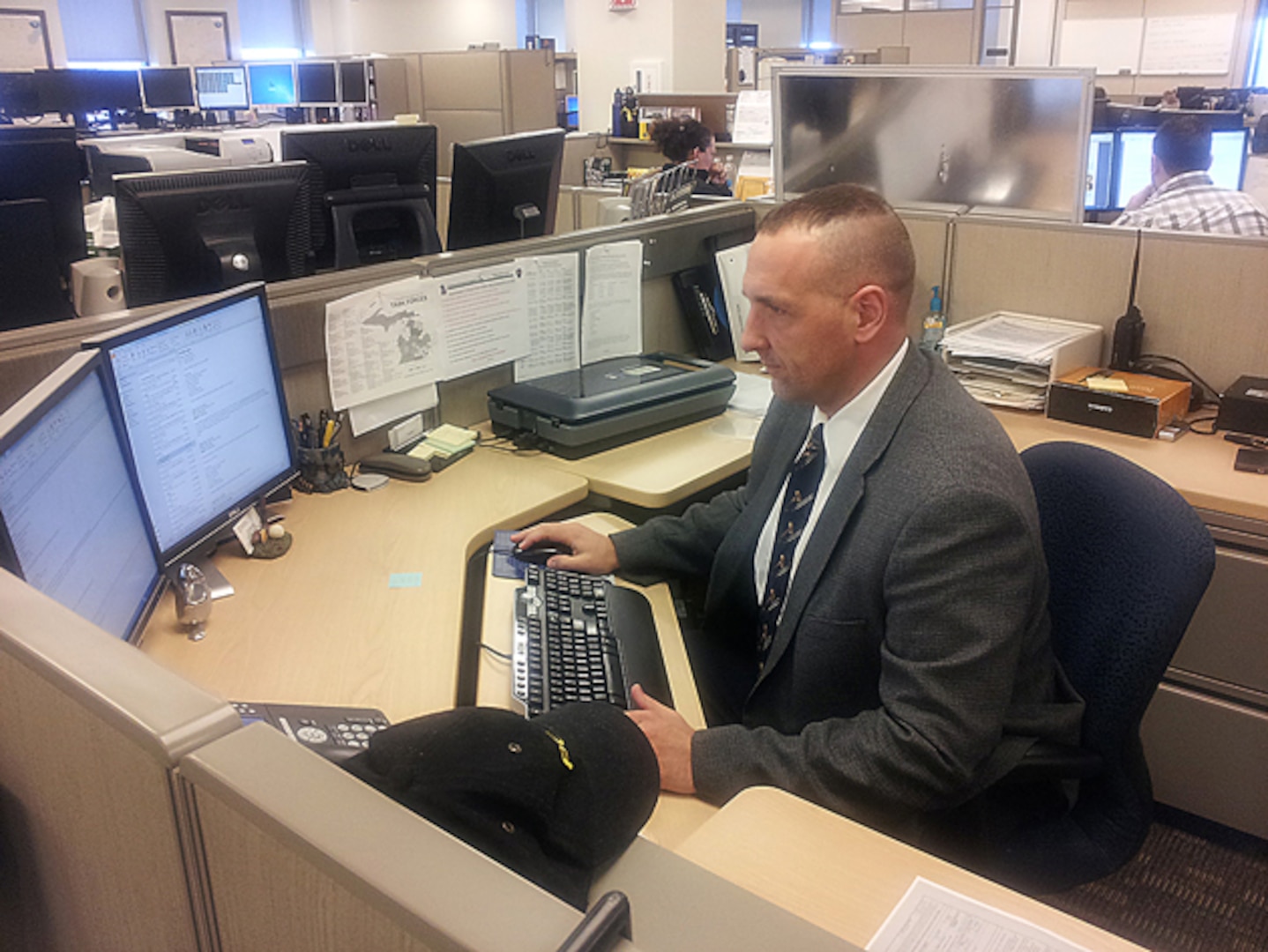 Michigan National Guard Counterdrug member Sgt. 1st Class Devin Hahn begins his workday April 8, 2015, as an analyst assigned to the Michigan Intelligence Operations Center in Lansing, Mich.  Hahn has been a member of the Counterdrug team for 15 years and is one of more than 20 full-time Michigan National Guard Soldiers and Airmen who assist law enforcement agencies in the detection of illegal drug activities within the Michigan community.